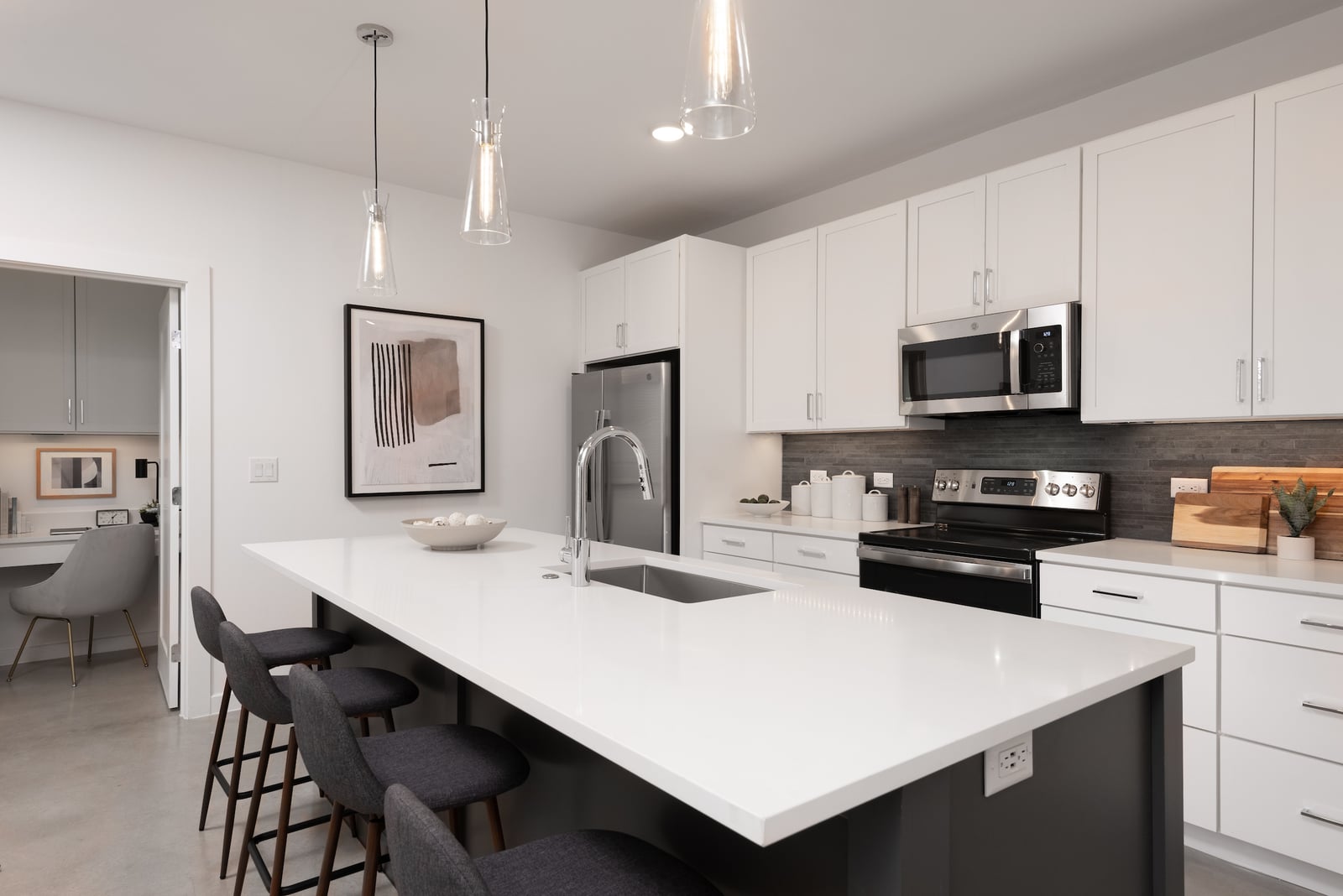 The Artesian at Bee Cave kitchen with white shaker cabinets, island seating and pendant lights