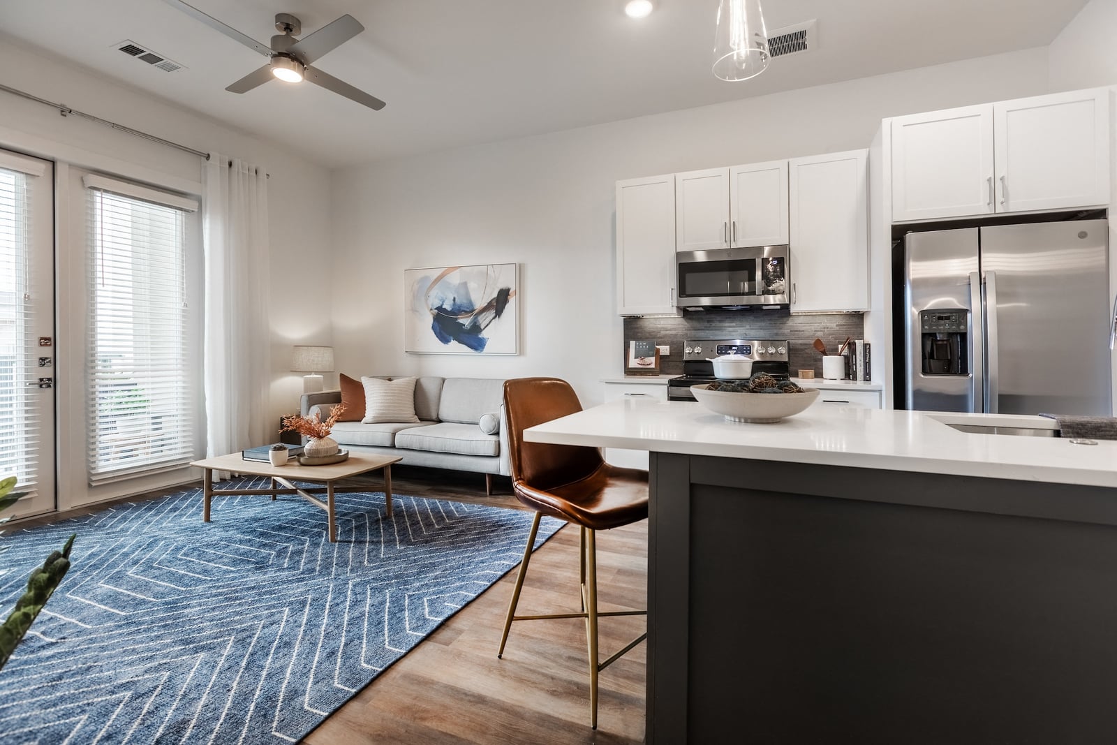 The Artesian at Bee Cave open-concept living room and kitchen in a one-bedroom model