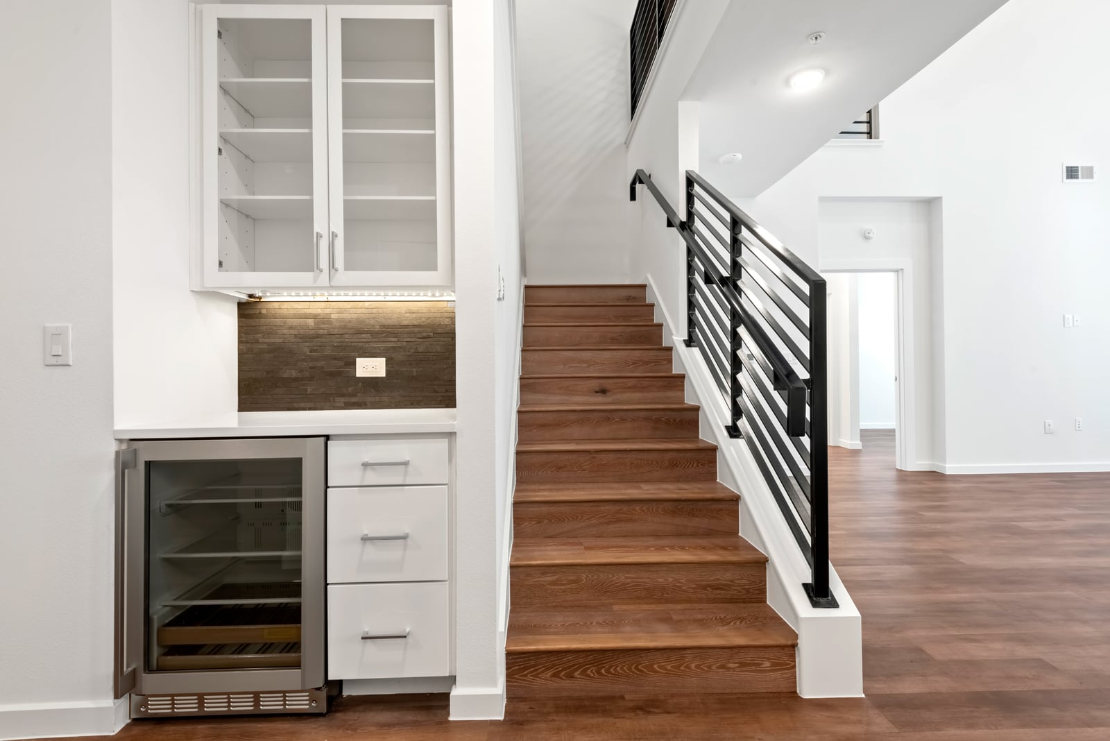 The Artesian at Bee Cave townhome wine fridge nook beside the stair with metal railing