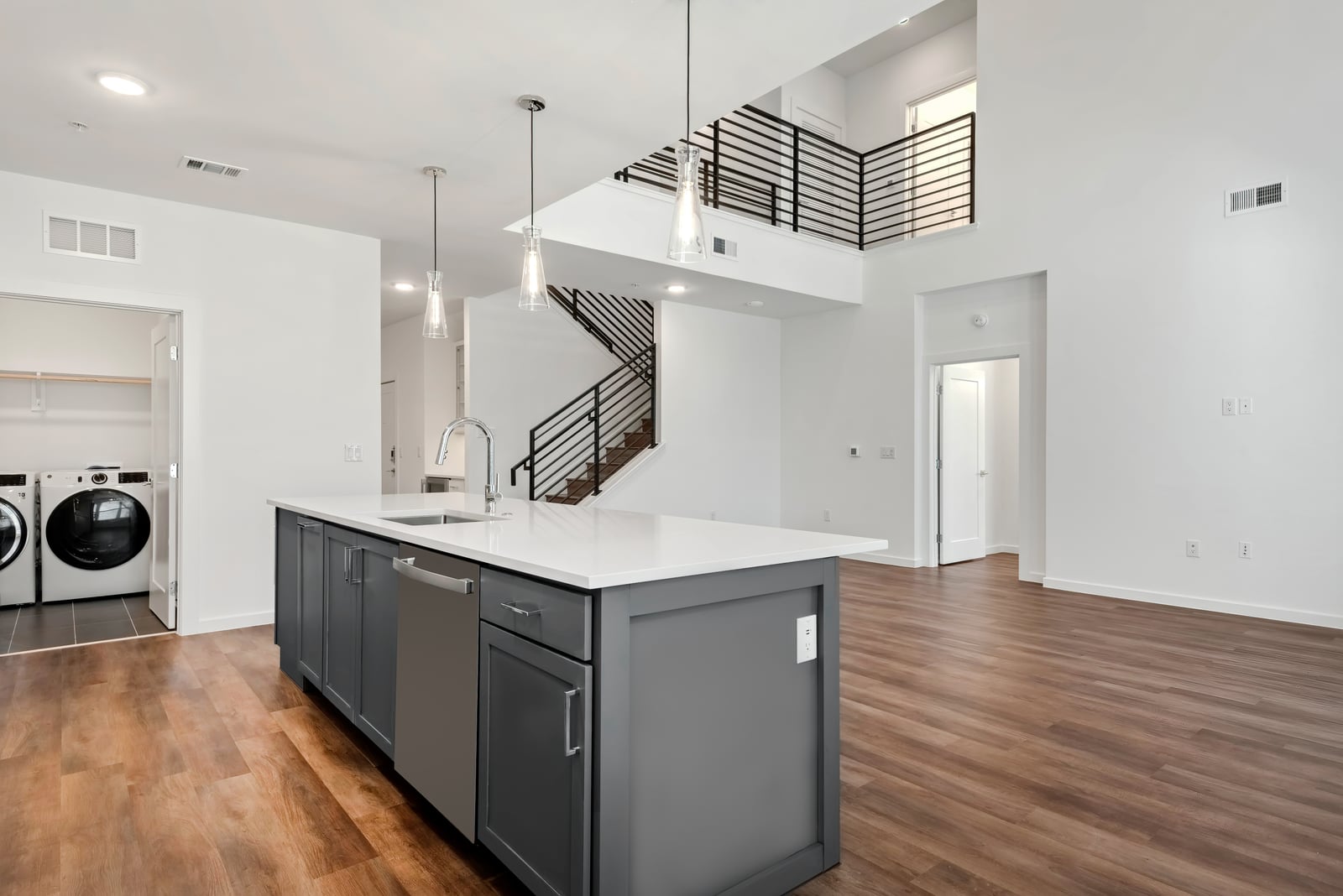 The Artesian at Bee Cave townhome kitchen island with laundry closet and open stair