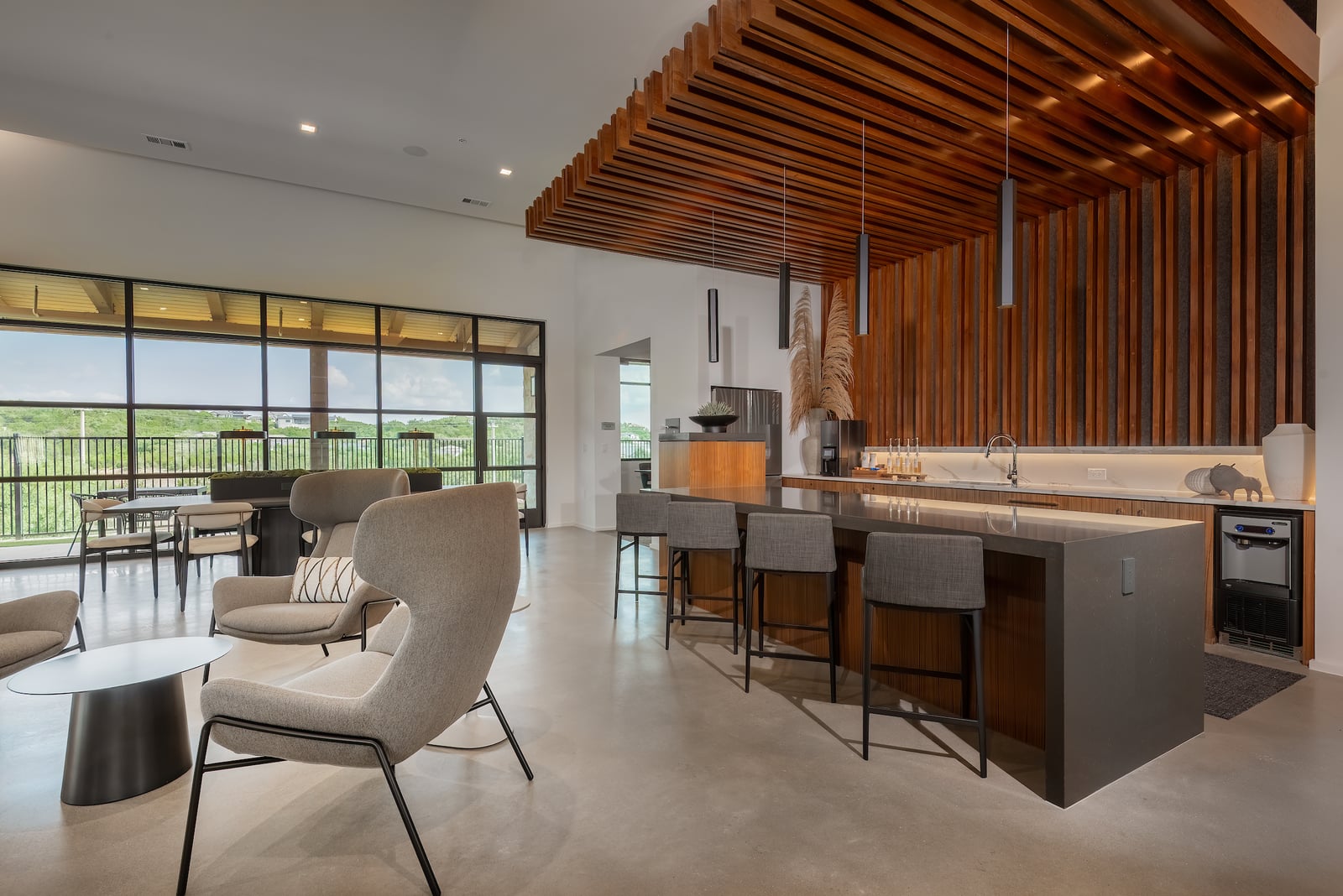 The Artesian at Bee Cave clubhouse kitchen with waterfall island and wood slat ceiling