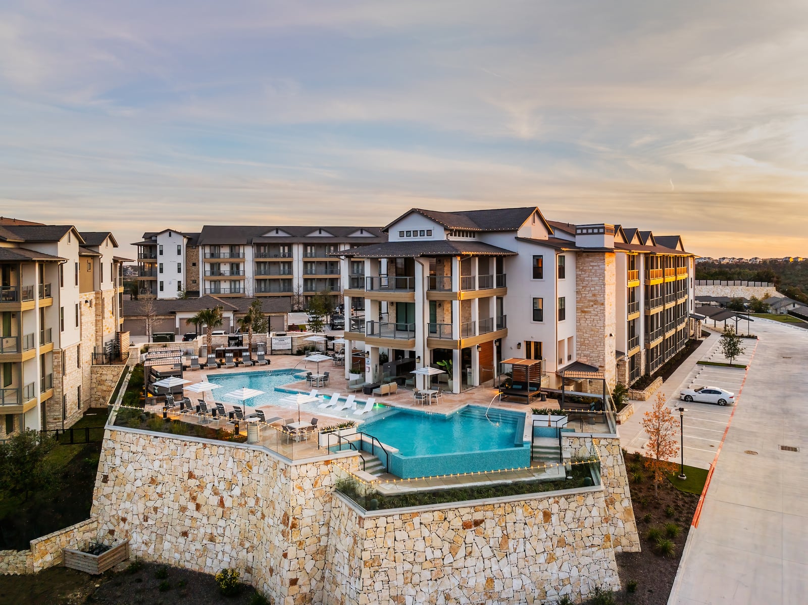 The Artesian at Bee Cave resort pool and apartment building at dusk, Bee Cave, TX