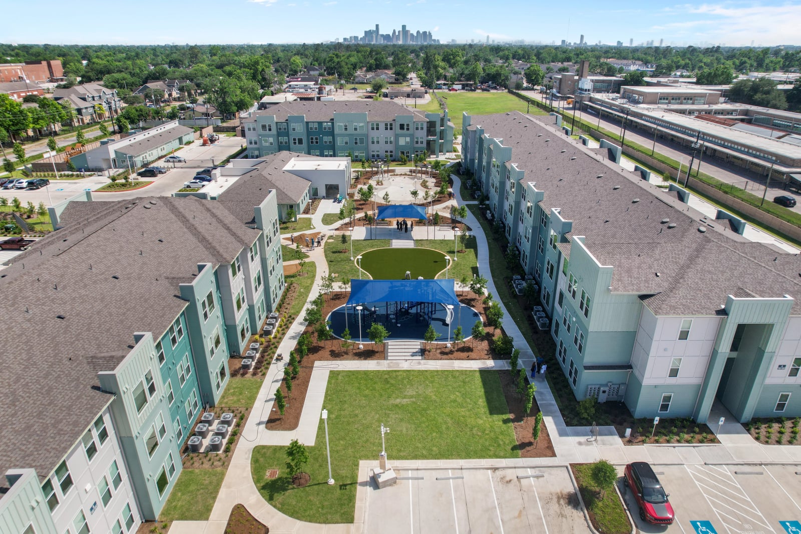 Berry affordable housing community aerial with courtyard and the Houston skyline, Houston, TX
