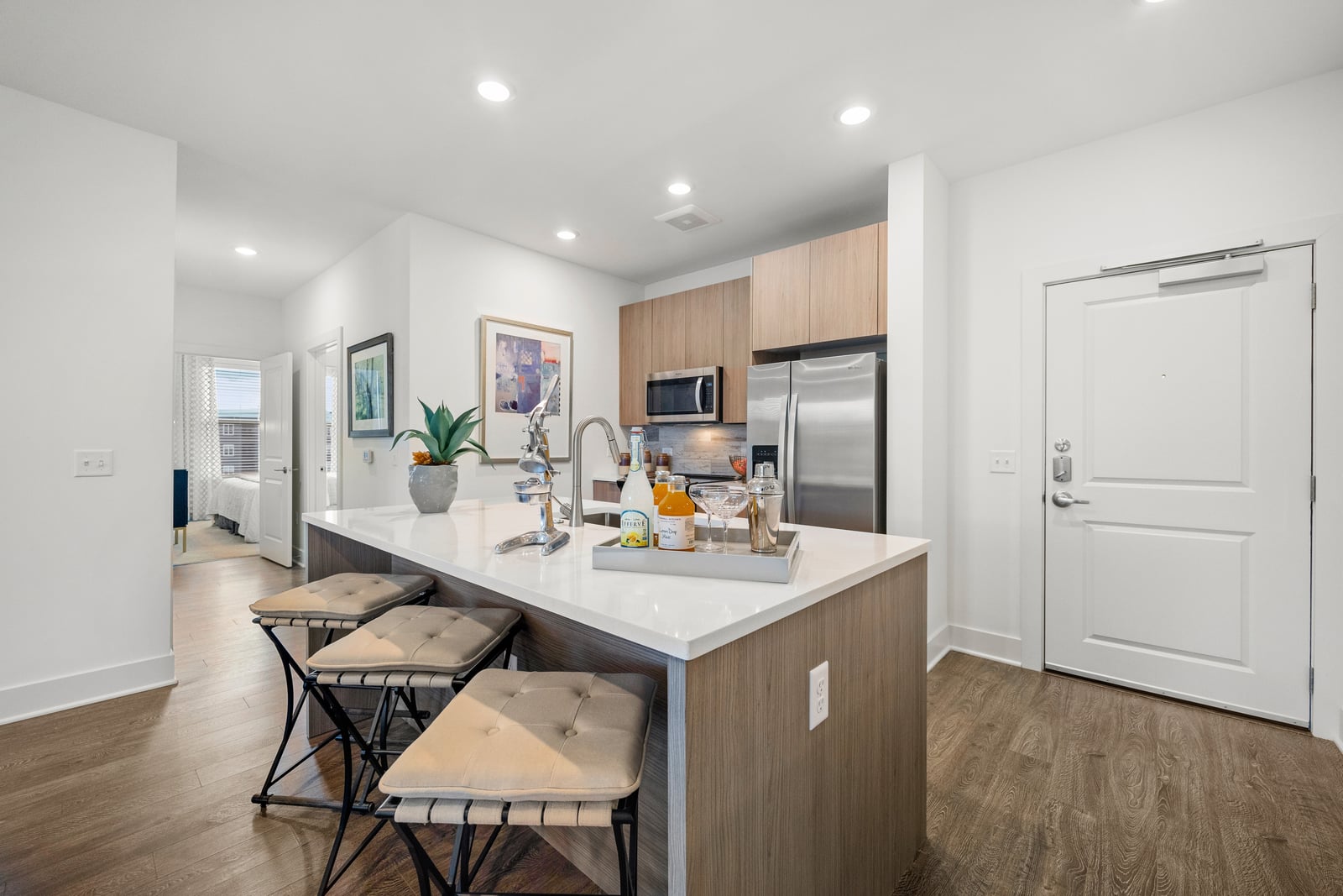 Colony Place kitchen island with white quartz counters and three stools