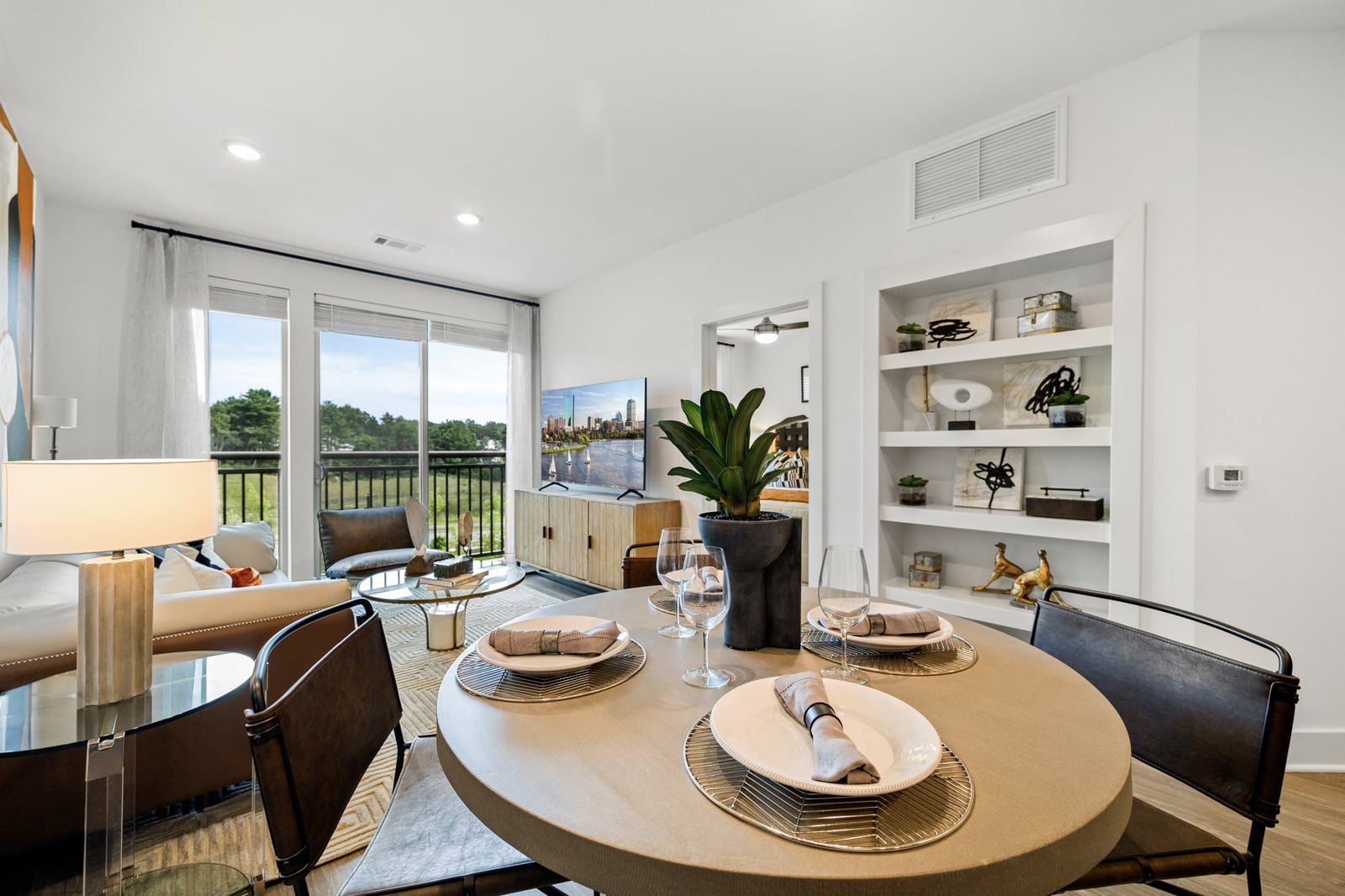 Colony Place living and dining area with built-in bookshelves and balcony