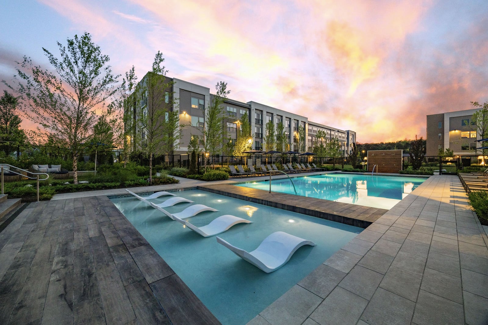 Colony Place resort-style pool with in-water loungers at sunset