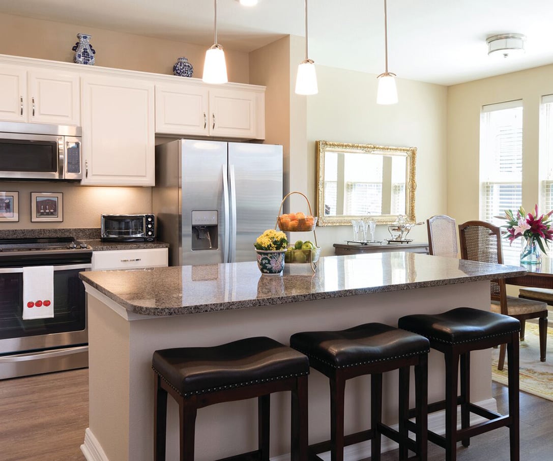 Eagle's Trace model kitchen with white cabinets and a granite island