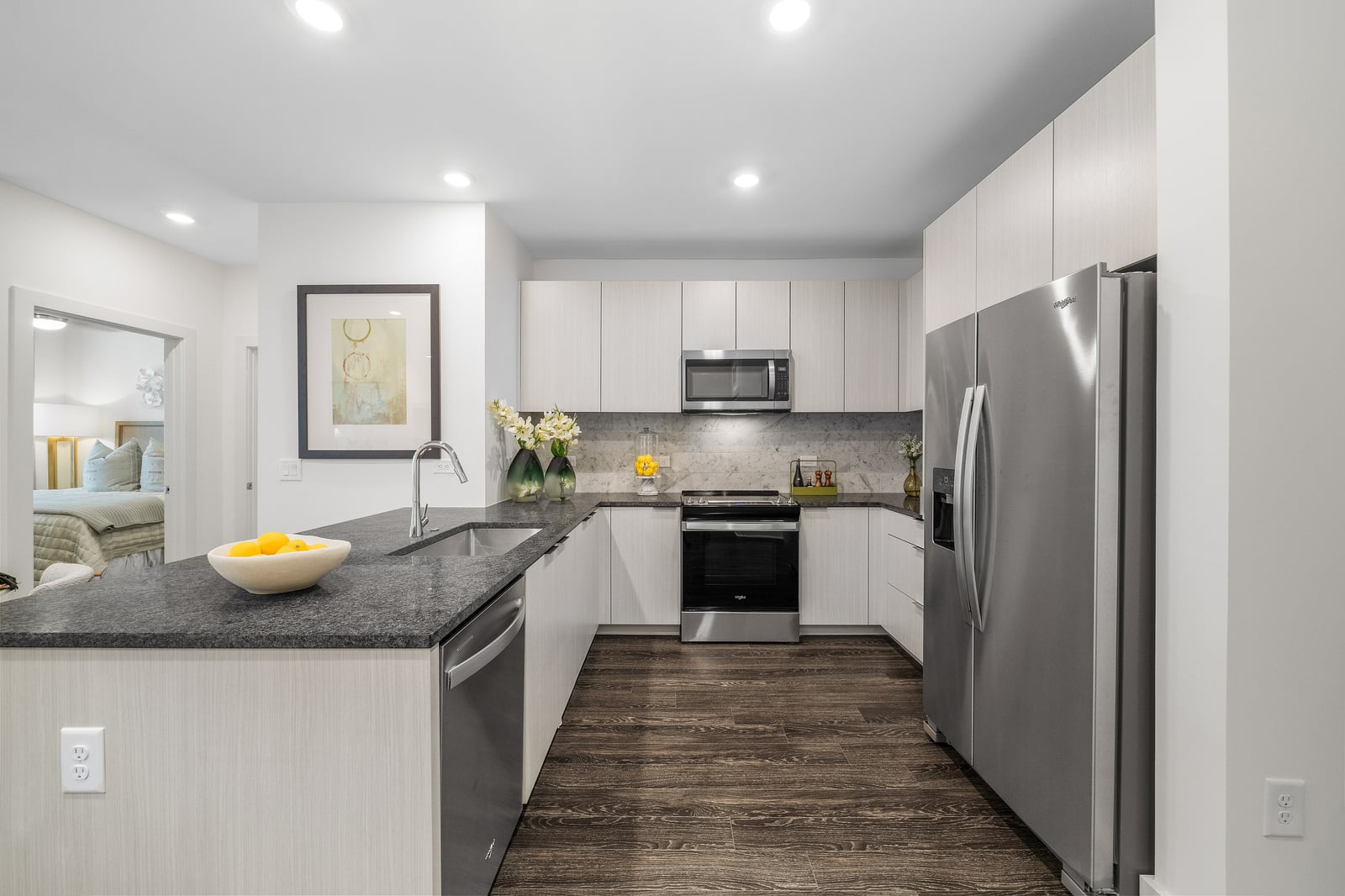 Edgewood kitchen with white cabinets, gray granite counters and marble backsplash