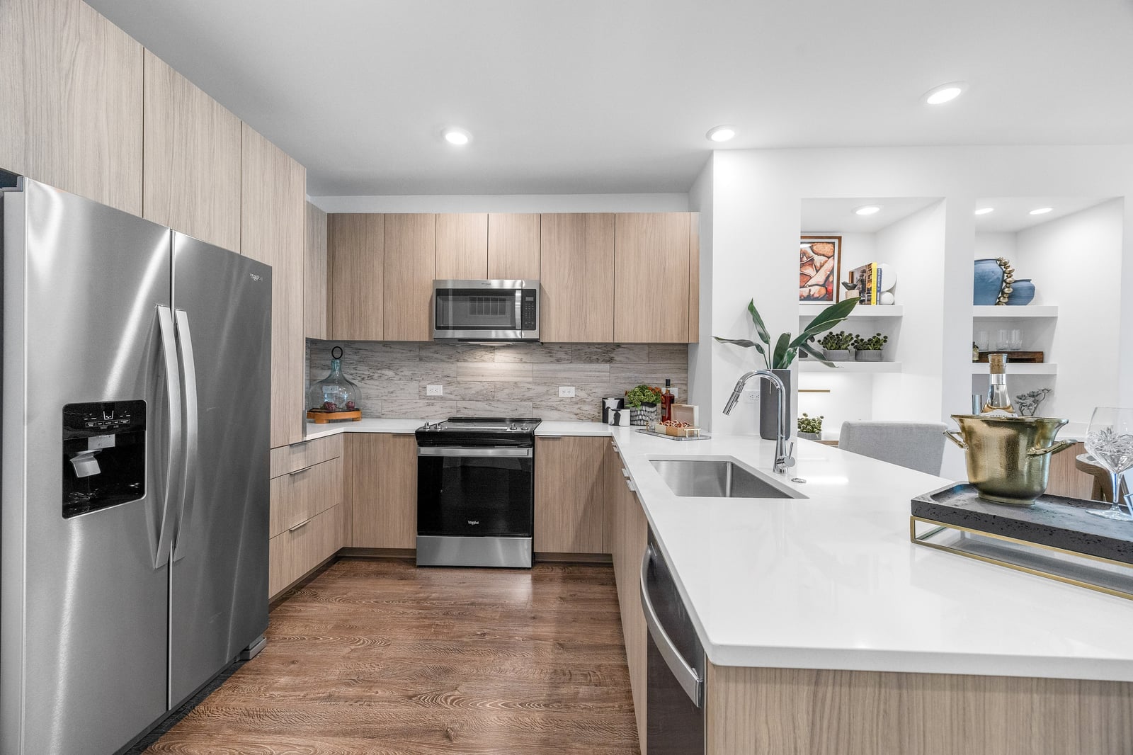 Edgewood kitchen with light wood cabinets, white quartz counters and built-in niches