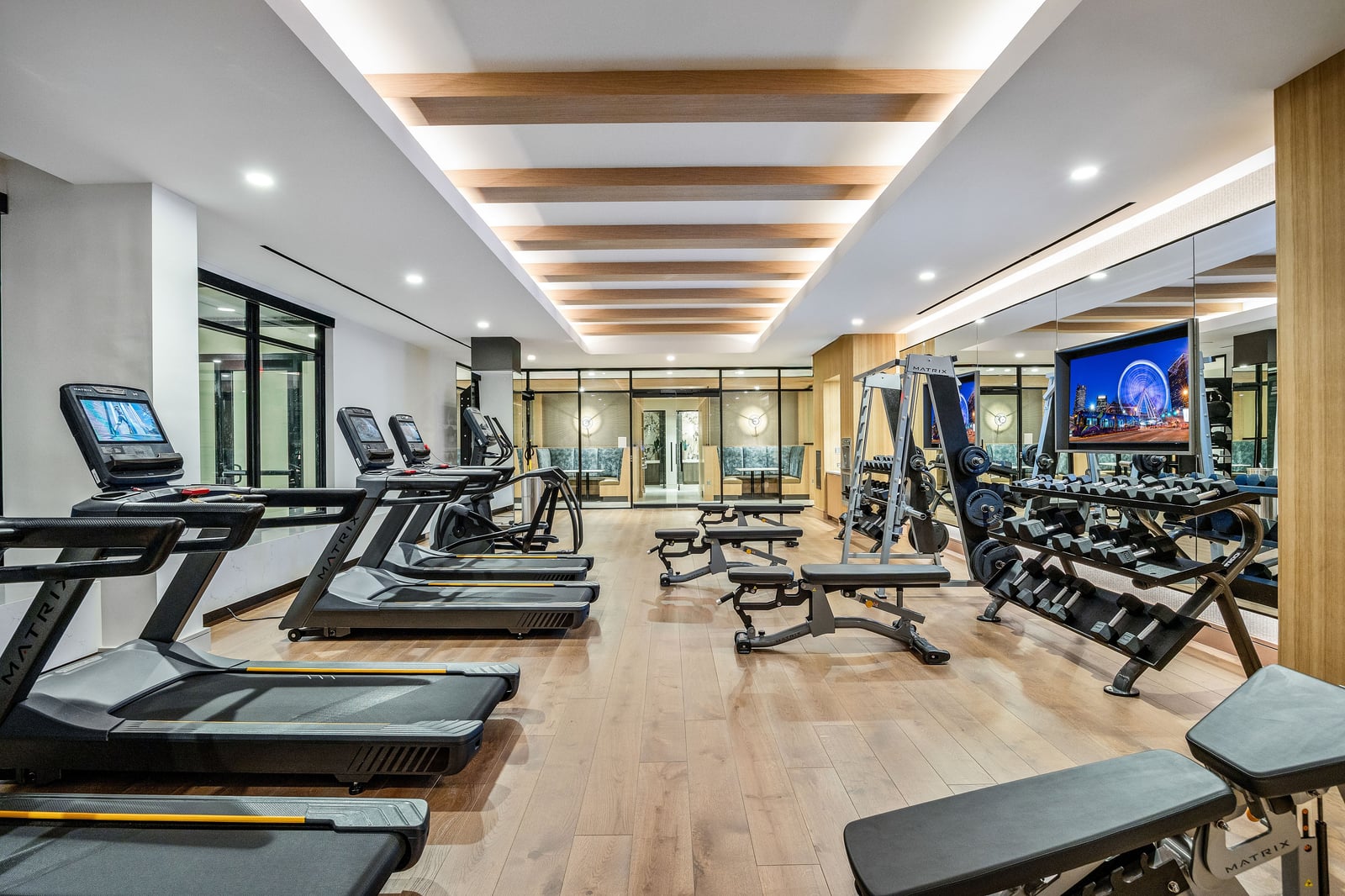 Edgewood fitness center with wood-slat ceiling and treadmills