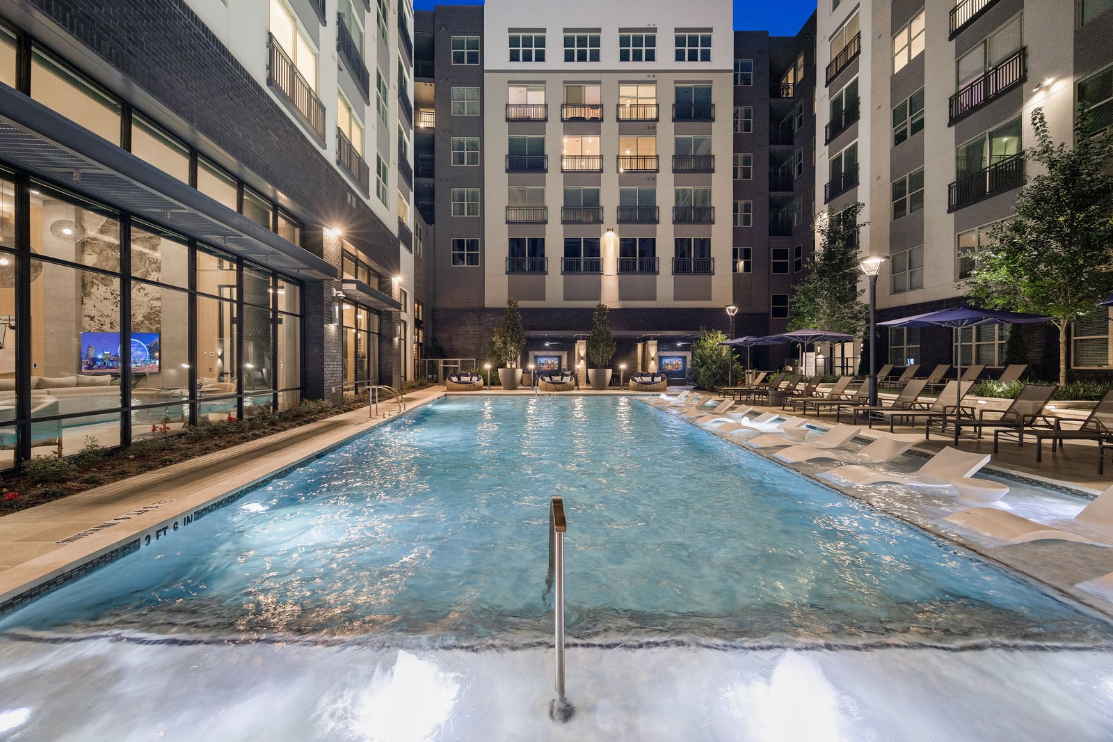 Edgewood courtyard pool with in-water loungers at night