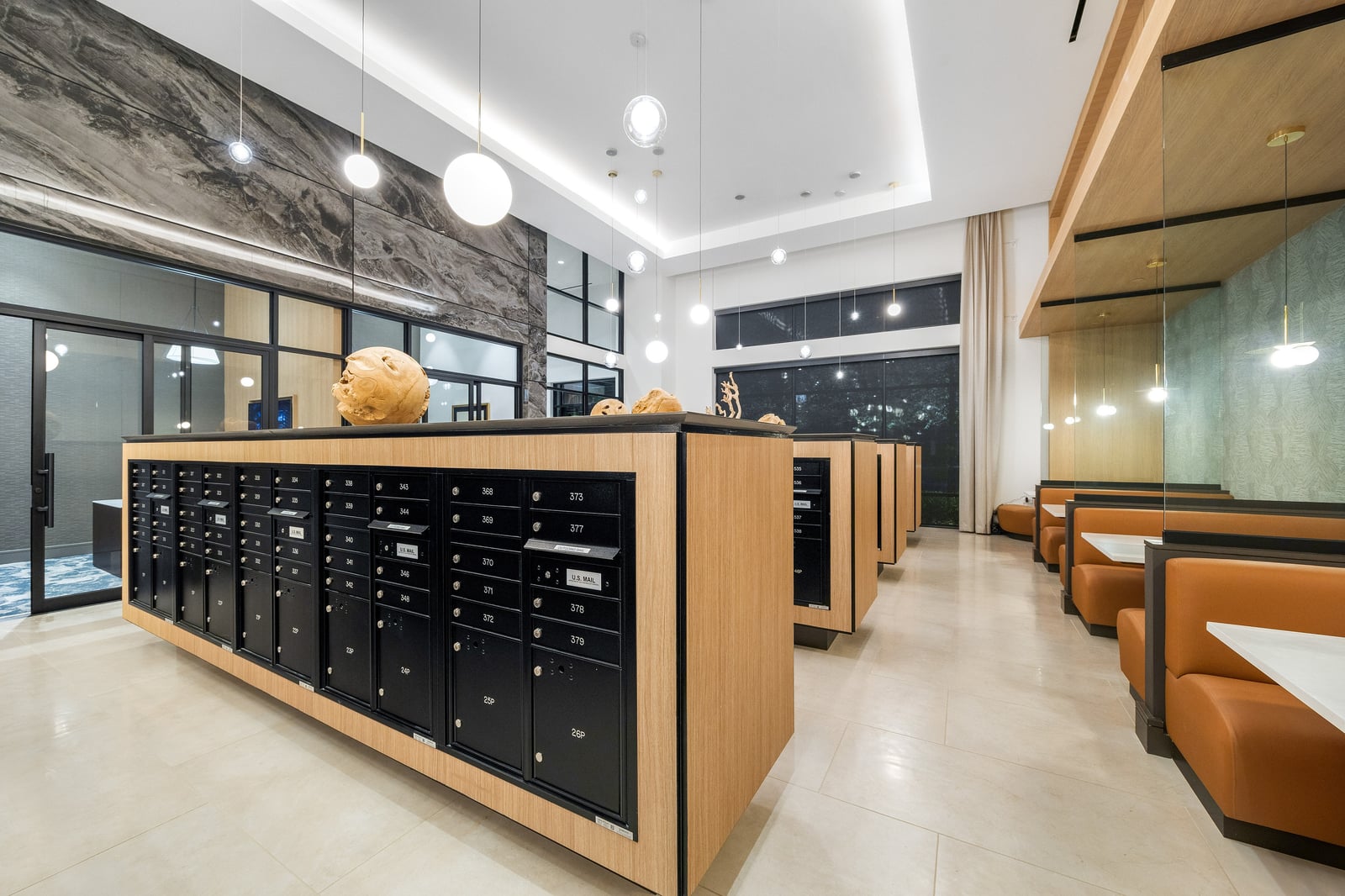 Edgewood mail room with wood-clad mailbox islands and booth seating