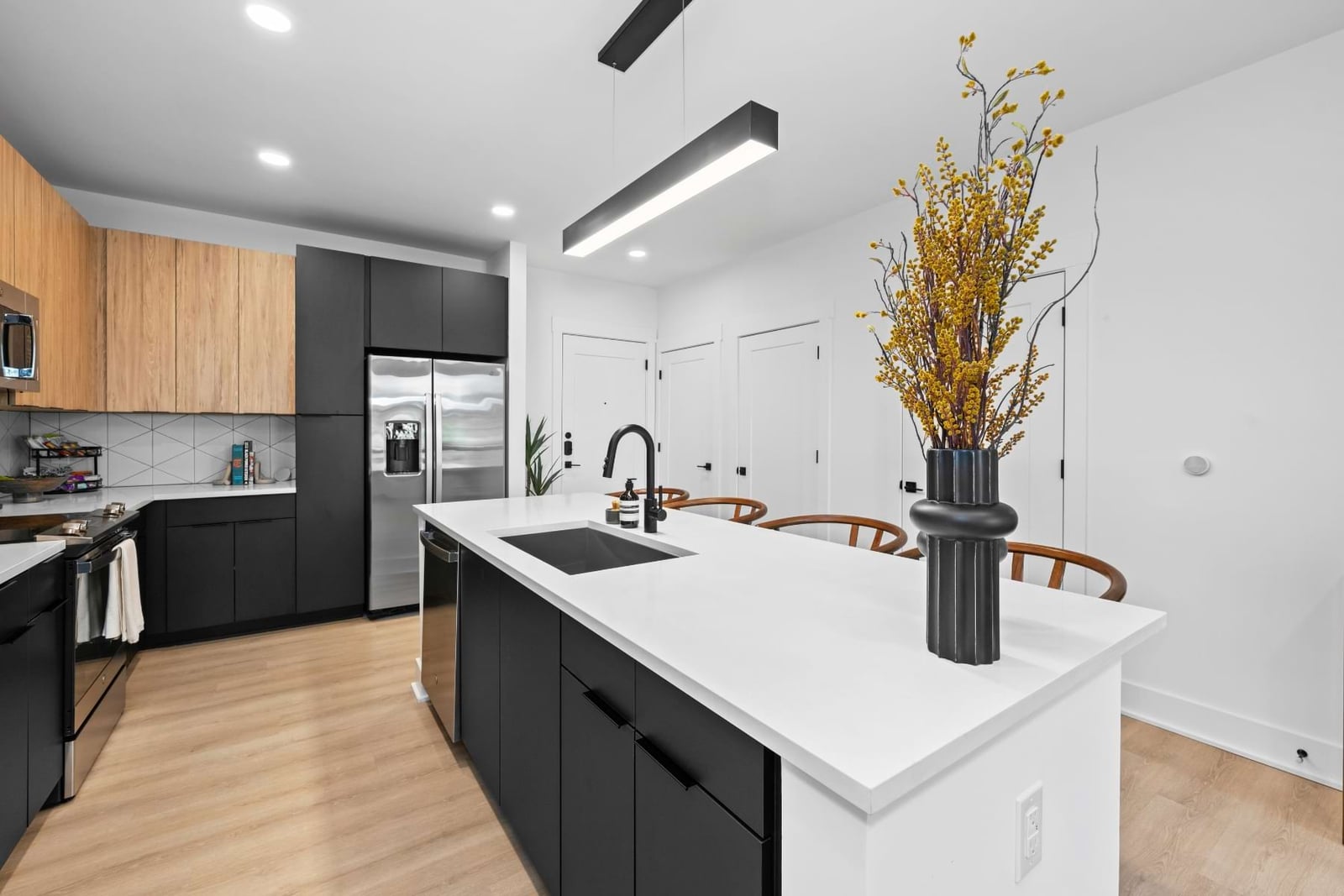 Elan LoSo kitchen with black and wood cabinets and a white quartz island
