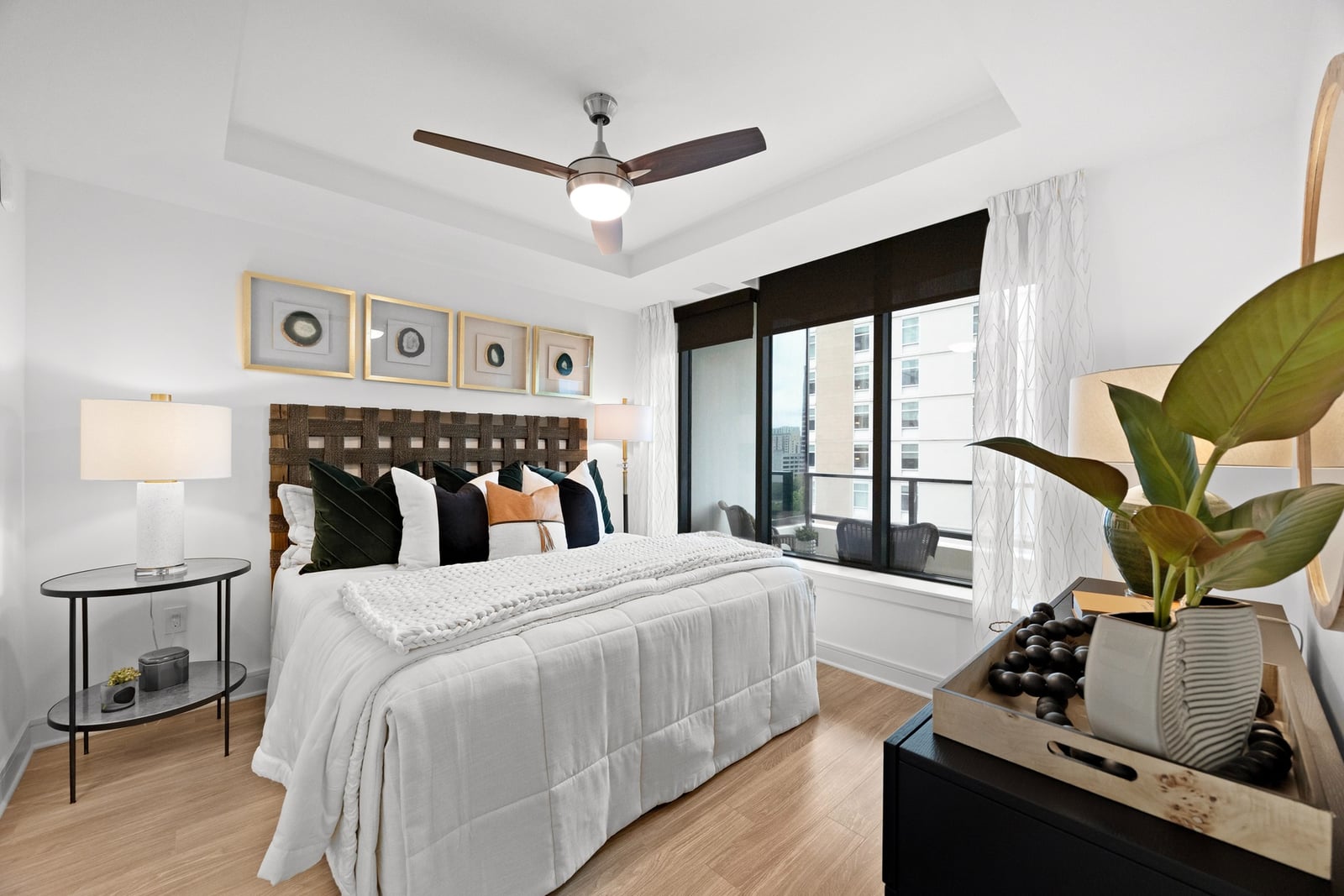 Midtown bedroom with tray ceiling, ceiling fan and balcony