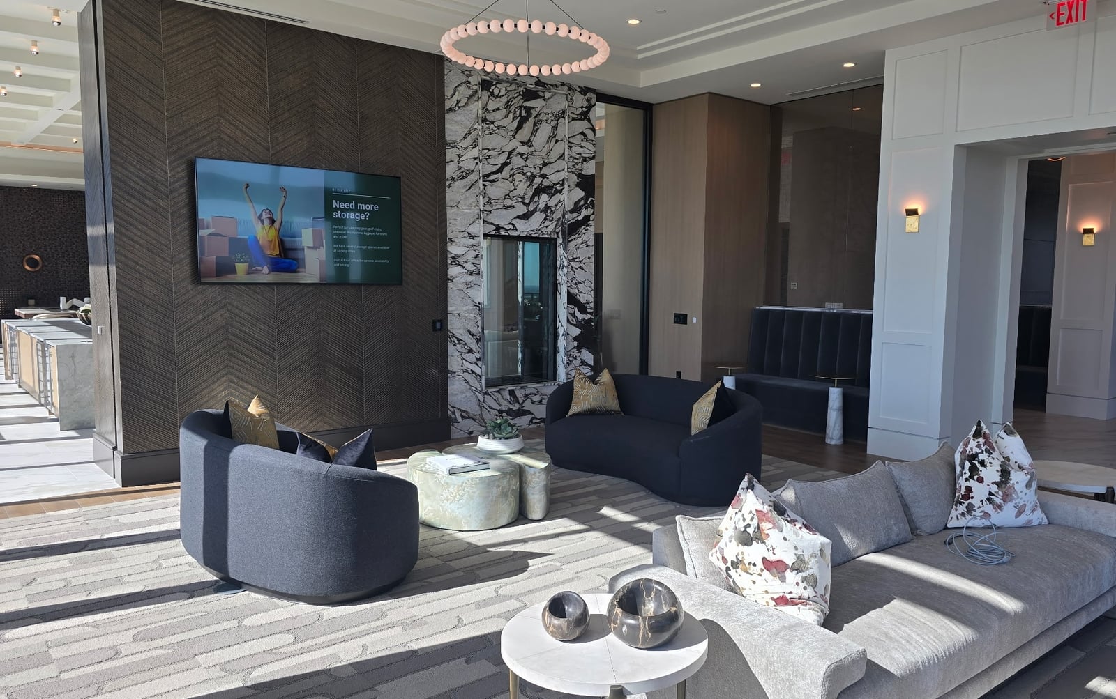 Preston Hollow resident lounge with curved sofas and a marble fireplace