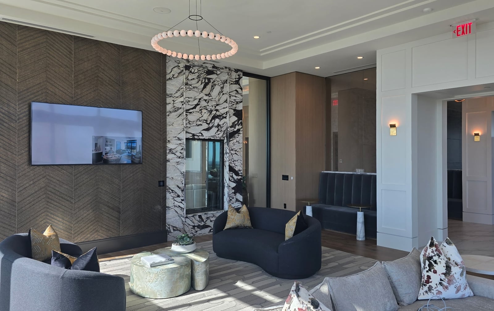 Preston Hollow resident lounge with a ring chandelier and marble fireplace