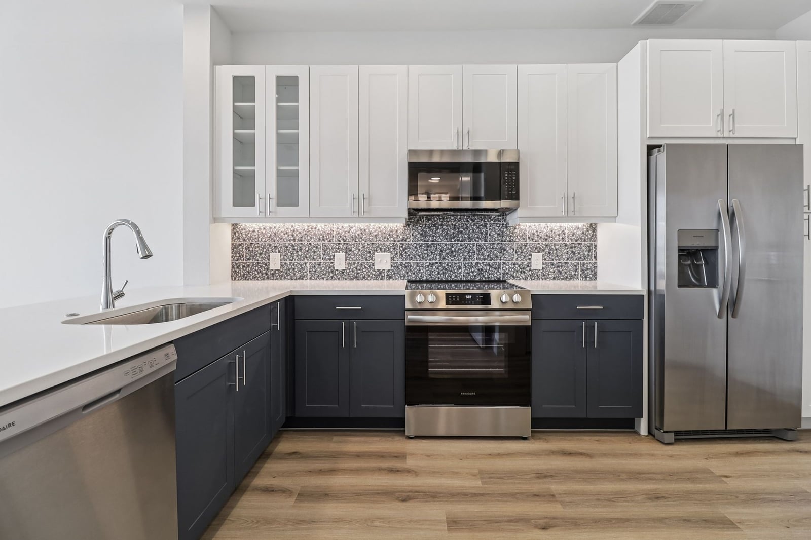 Surfside at Sapphire Bay kitchen with white upper cabinets, navy base cabinets and terrazzo backsplash