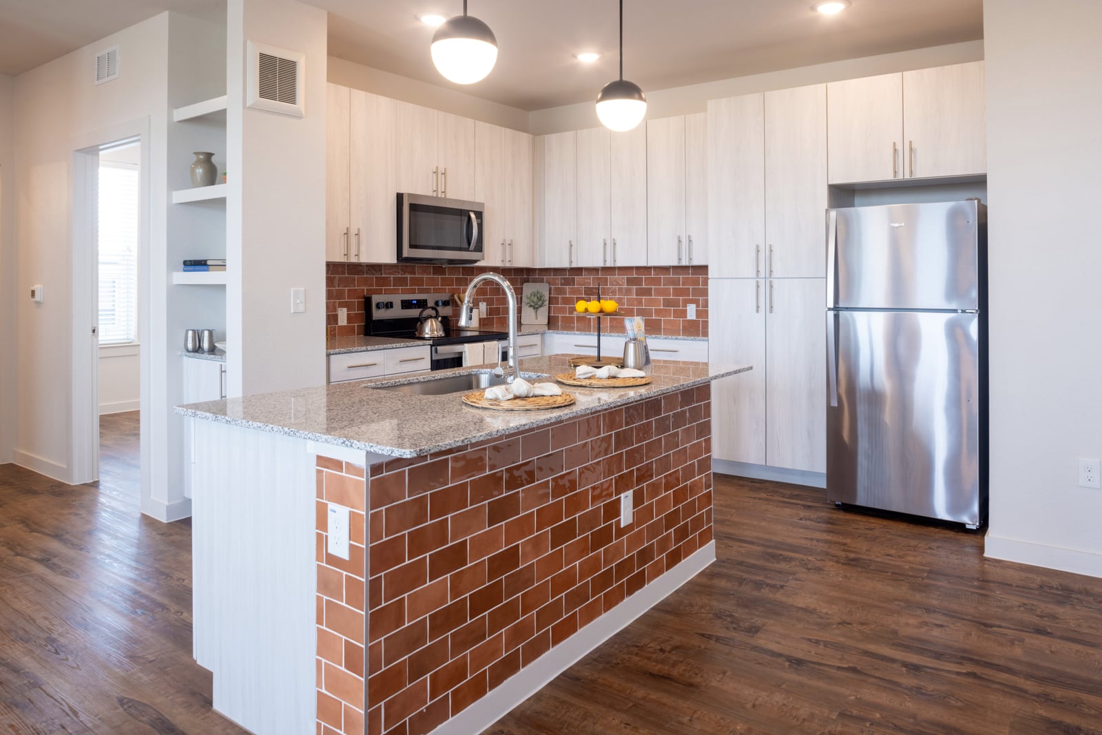 The Rhett three bedroom kitchen with brick tile island and pendant lights
