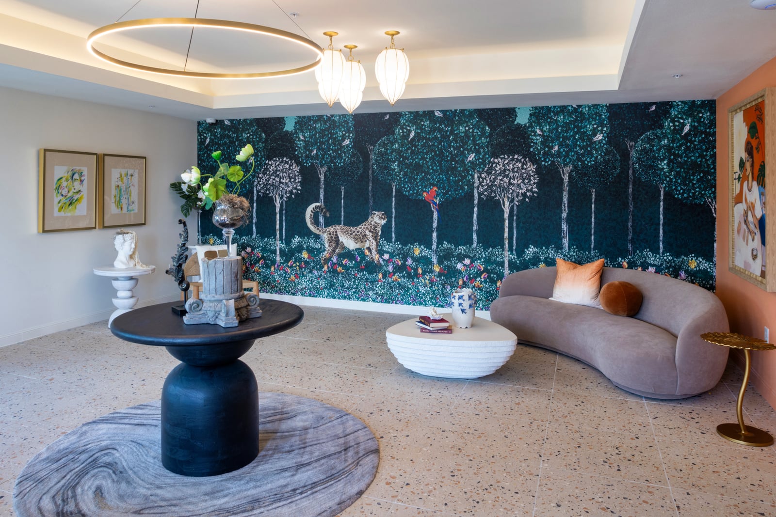 The Rhett lobby with a forest mural, terrazzo floor and curved sofa