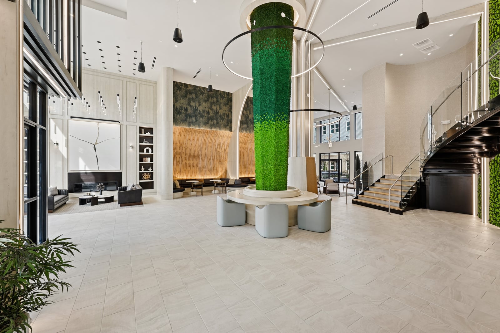 Wellory Living two-story lobby with moss-covered column and feature stair